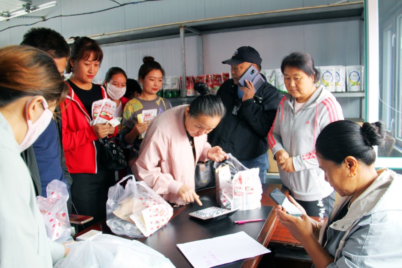 工会党员干部职工在徐江家的小店内帮忙售货。（王清新）
