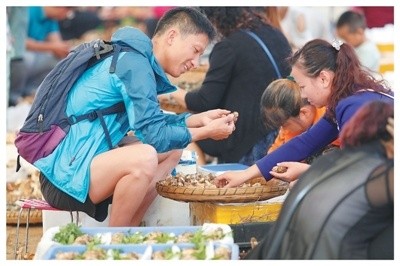 在云南木水花野生菌交易中心，游客在選購松茸。楊崢 攝（影像中國）