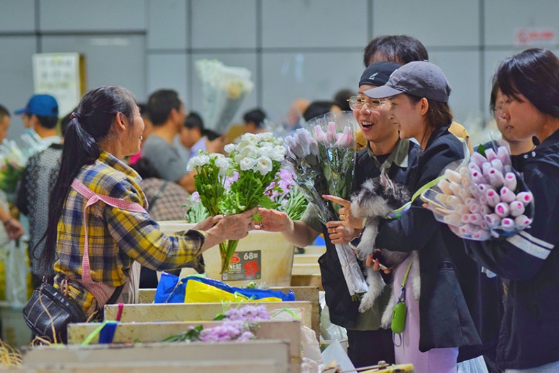 游客在斗南花市場(chǎng)挑選鮮花。朱家霖?cái)z