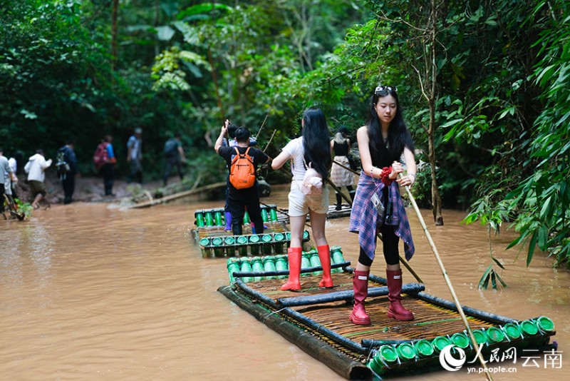 游客在西雙版納基諾山熱帶雨林中乘竹筏溯溪，感受別樣意境。人民網(wǎng) 曾智慧 攝