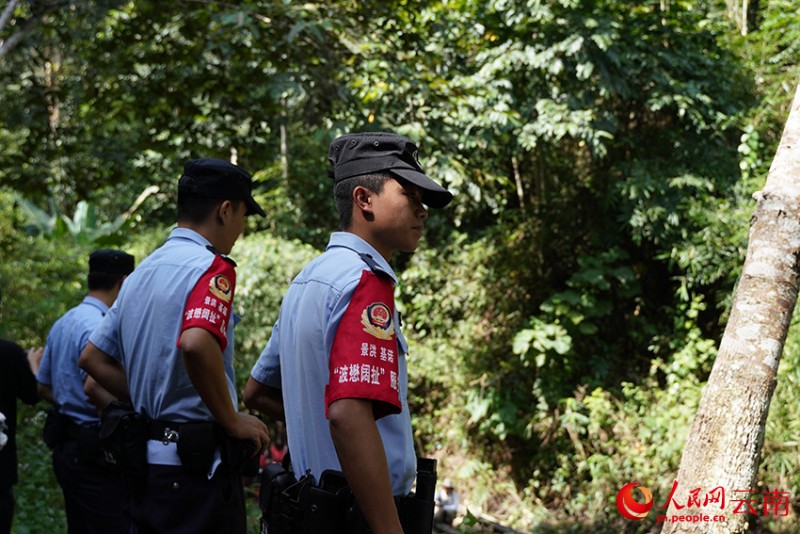 基諾山鄉(xiāng)派出所“波懋闊扯”服務(wù)隊進(jìn)山巡邏時在水邊看護(hù)游客。人民網(wǎng)記者 蔡樹菁攝