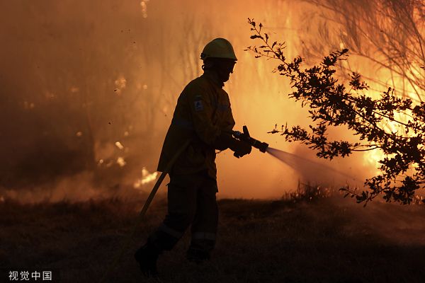 当地时间2022年8月18日，葡萄牙埃什特雷拉山脉，一名消防队员正在扑灭山火。视觉中国 图