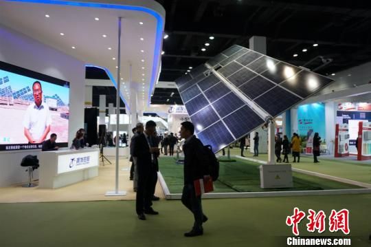 第八届中国无锡国际新能源大会暨展览会，参观嘉宾在硕大的太阳能板下停留。 孙权 摄