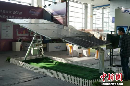 第八届中国无锡国际新能源大会暨展览会，参观嘉宾在硕大的太阳能板下停留。 孙权 摄